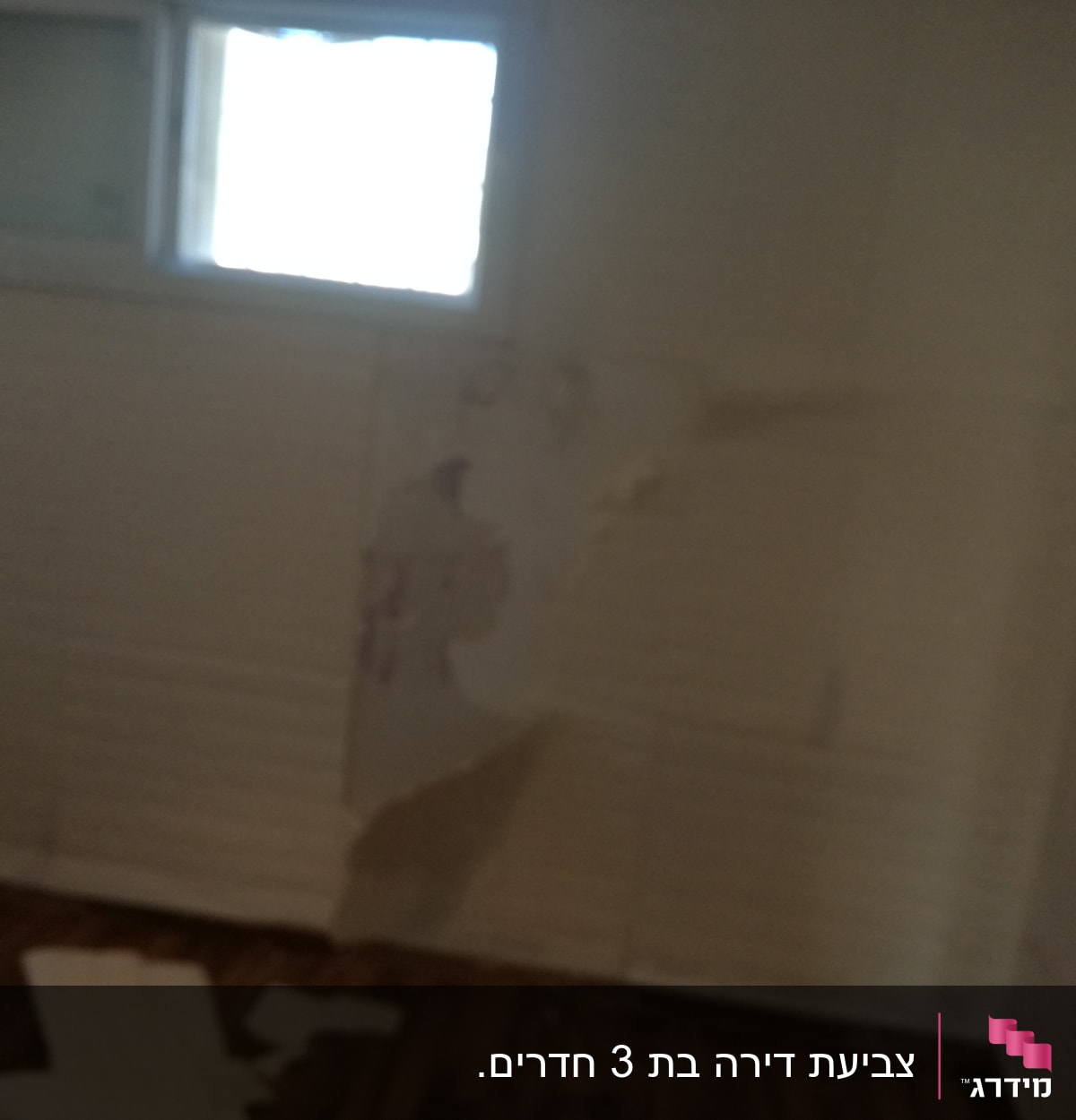 קיר עם טפט מתקלף וחלון קטן